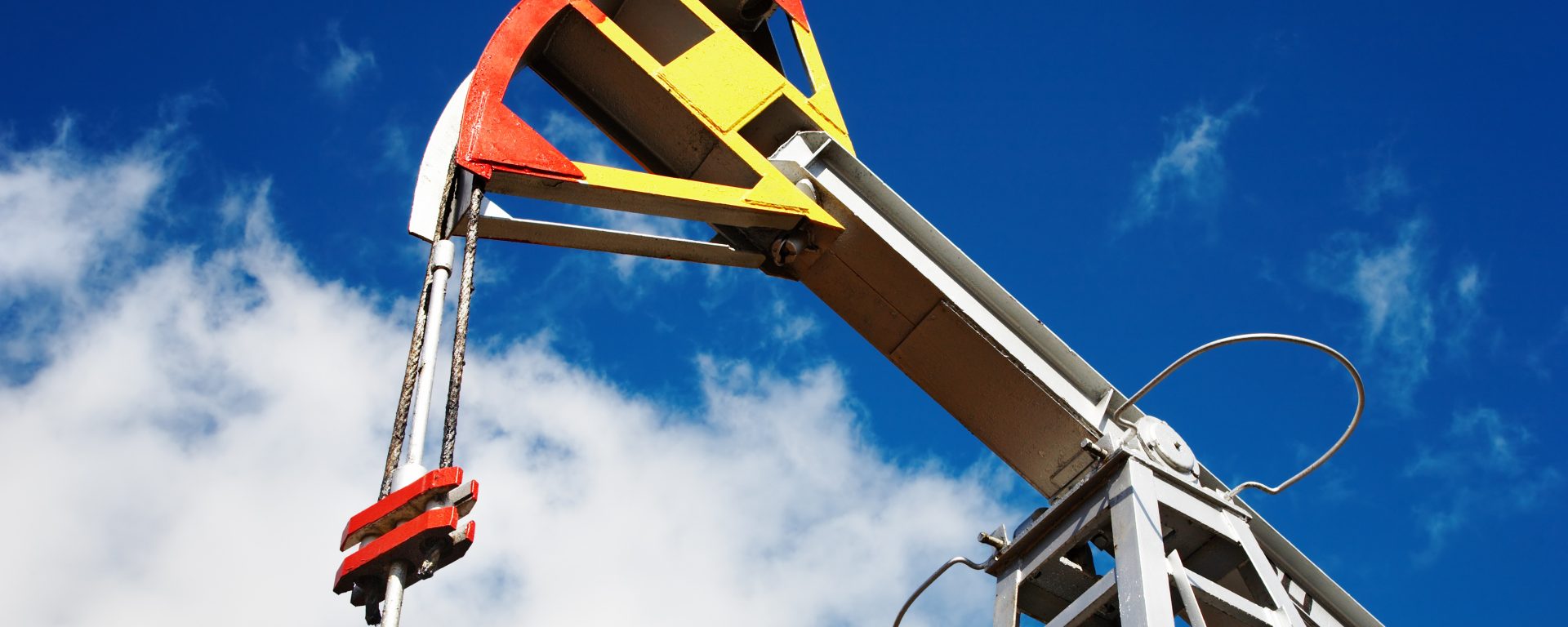 Oil pump jack against blue sky background