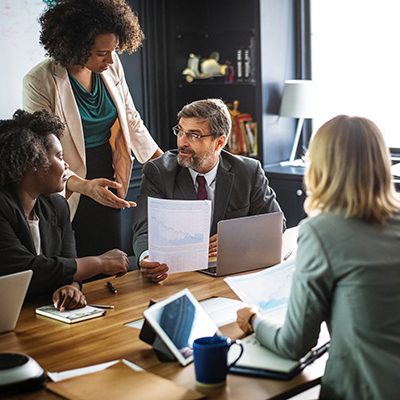 Professionals at table with charts and graphs