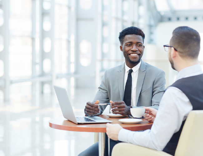 Image of two men sitting and discussing a business plan