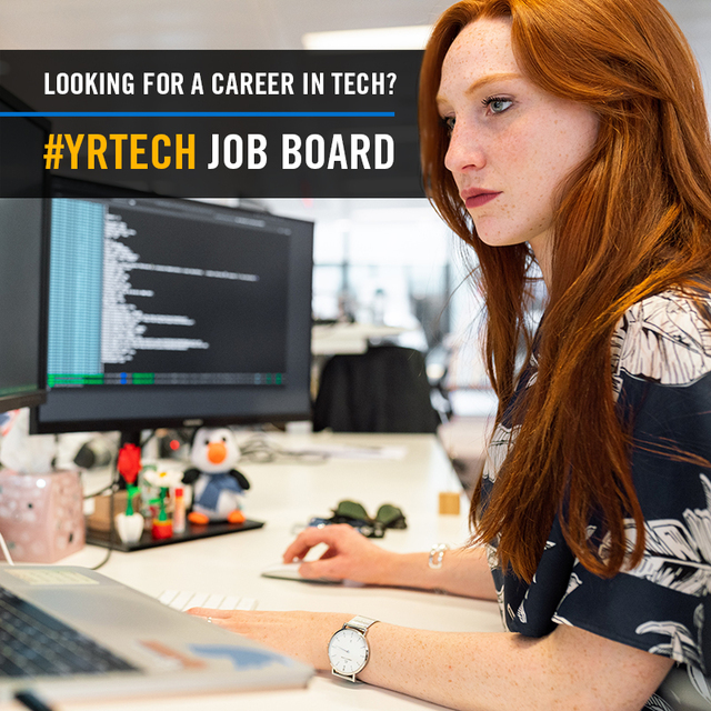 Woman working at a desk with code in the background