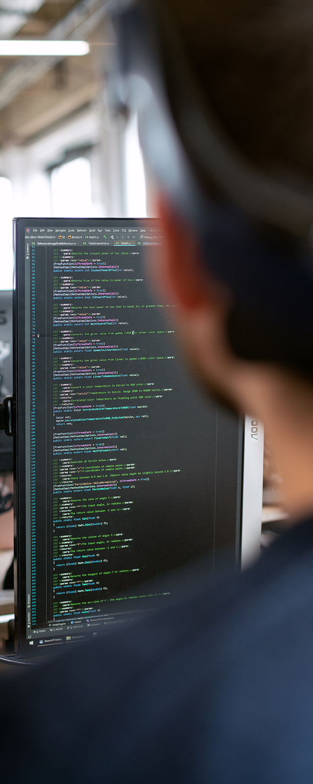 Man coding with a vertical monitor