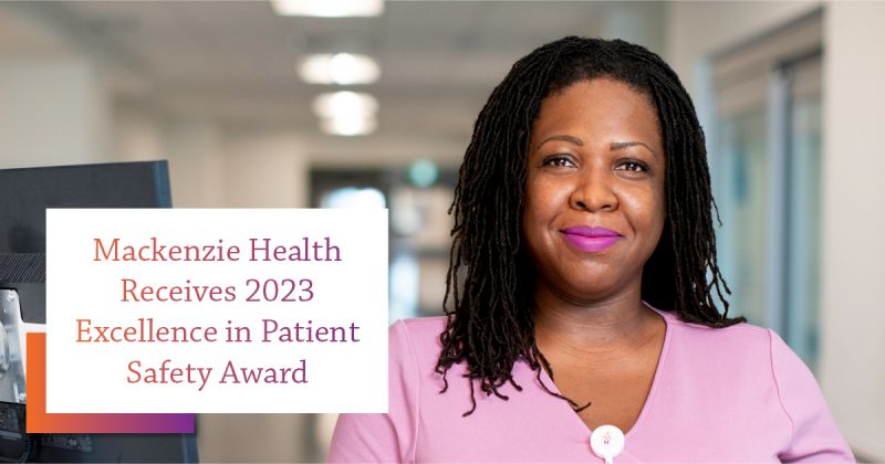 Female hospital worker, wearing pink, posing in a hospital hallway, with text over image reading, Mackenzie Health Receives 2023 Excellence in Patient Safety Award.