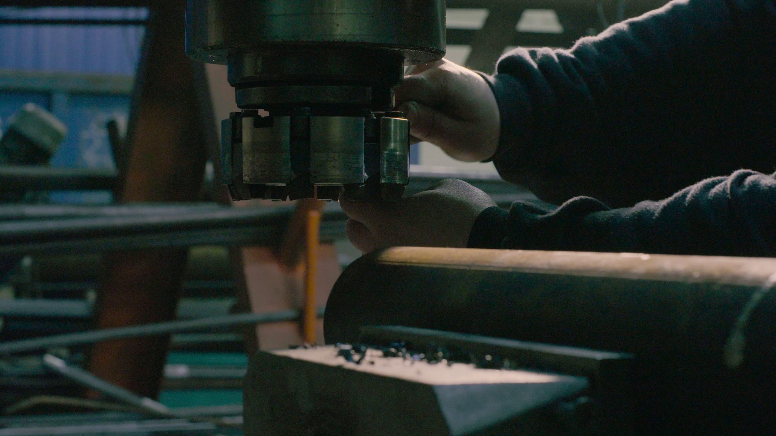 Close up of men's hands screwing the milling cutter on the milling machine
